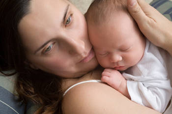 Worried mother holding newborn