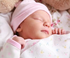 Newborn sleeping with pink hat