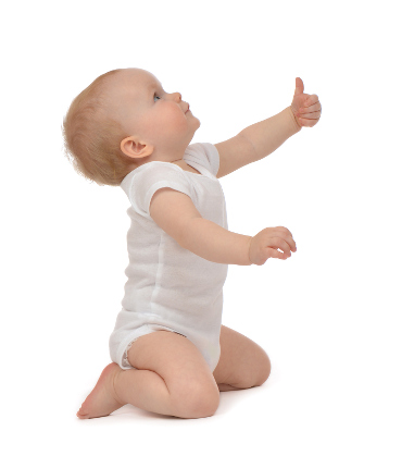 Small baby sitting on knees holding thumbs up
