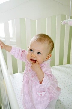 Cute baby standing in crib