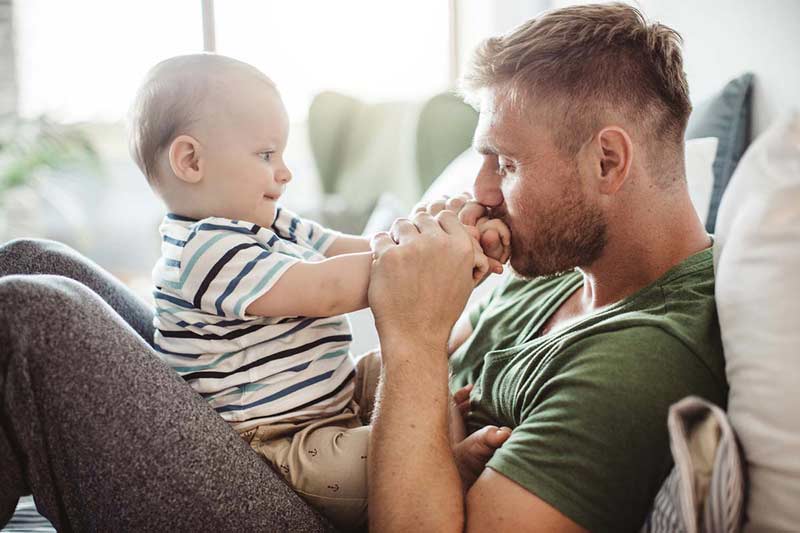 Dad holding his baby on his knees