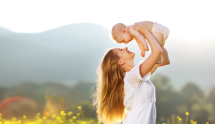 Mom holding happy baby in nature