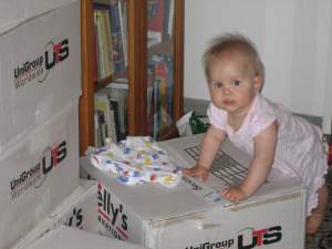 Ten months old baby unpacking removal boxes