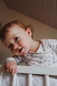 My daughter happily playing in her crib